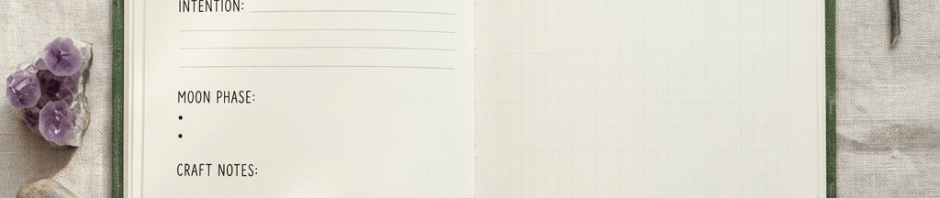 Open journal with pages titled Weekly Rituals & Reflections and Magical Notes, surrounded by crystals, a pen, and a twig